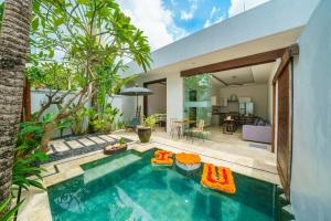 a swimming pool in a backyard with a house at Anema Villa Seminyak in Legian