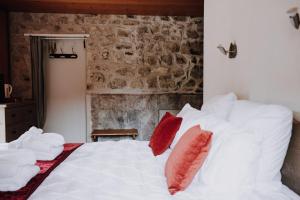 Schlafzimmer mit einem weißen Bett und roten Kissen in der Unterkunft Kern in Seytroux