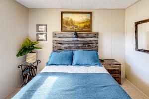 a bedroom with a bed with a wooden headboard at Fairways & 14ers in Estes Park