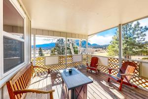 a porch with two chairs and a table on it at Fairways & 14ers in Estes Park