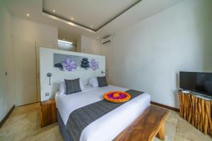 een slaapkamer met een wit bed met een kom erop bij Anema Villa Seminyak in Legian