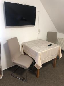a table with two chairs and a tv on the wall at Schozacher Stüble in Talheim