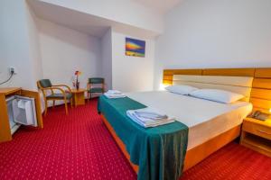 a hotel room with a bed and a table and chairs at Hotel Sir Orhideea in Bucharest