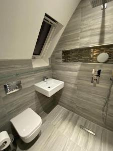 a bathroom with a white toilet and a sink at Luxury 4 bed house in Swindon in Swindon