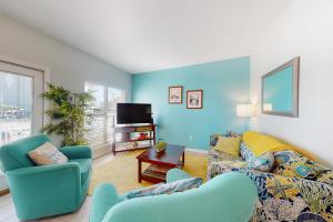 sala de estar con sofá, sillas y TV en Sun & Sea, en Gulf Shores