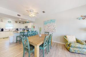 cocina y comedor con mesa de madera y sillas en Sun & Sea, en Gulf Shores