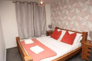 a bedroom with a bed with red pillows at Luxury 4 bed house in Swindon in Swindon