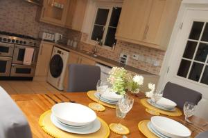 a wooden table with plates and dishes on it in a kitchen at Luxury 4 bed house in Swindon in Swindon