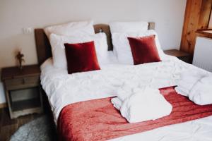 a large white bed with red and white pillows at Kern in Seytroux
