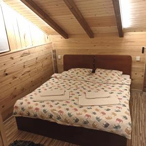 1 dormitorio con 1 cama en una habitación de madera en Villa FORESTA, en Banja Luka