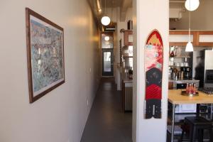 a hallway of a kitchen with a surfboard on a wall at NEW! Lavish Studio Loft in Central Downtown SLC in Salt Lake City