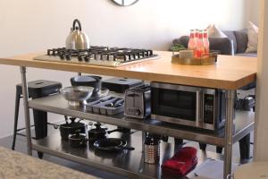 a kitchen with a stove and a microwave on a table at NEW! Lavish Studio Loft in Central Downtown SLC in Salt Lake City