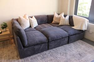 a couch in a living room with pillows on it at NEW! Lavish Studio Loft in Central Downtown SLC in Salt Lake City