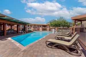 a swimming pool with lounge chairs next to a building at Best Western Red Hills in Kanab