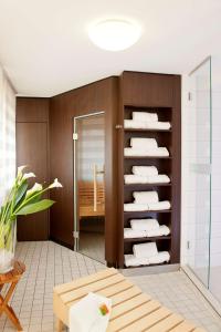 um quarto com uma casa de banho com toalhas numa prateleira em NH Fürth Nürnberg em Fürth
