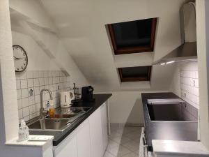 chez WF في لوكسمبورغ: مطبخ مع حوض وساعة على الحائط