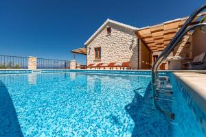 ein Schwimmbad mit einem Haus im Hintergrund in der Unterkunft Villa Endless View in Blato