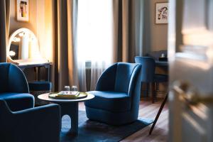 a room with blue chairs and a table and a window at Hotel Ruth, WorldHotels Crafted in Stockholm