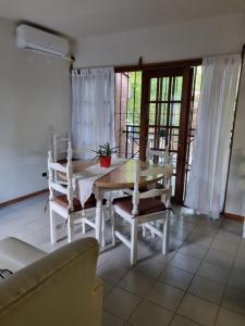 een witte eetkamer met een tafel en stoelen bij Departamento en complejo residencial in Mendoza