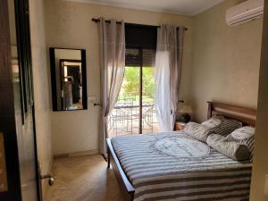 a bedroom with a bed and a door to a balcony at Atlas Golf Resort Marrakech in Marrakech
