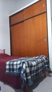a bedroom with a bed with a wooden door at casa de mar in Las Grutas