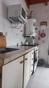 a kitchen with a sink and a microwave at casa de mar in Las Grutas