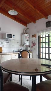 cocina con mesa en el centro de una habitación en casa de mar en Las Grutas