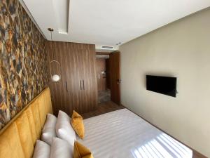 ein Schlafzimmer mit einem Bett und einem TV an der Wand in der Unterkunft Modern 1 BR, 1min from Downtown Anoual Tramway in Casablanca