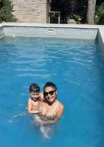 a man and a child in a swimming pool at Óga Rory in Corrientes