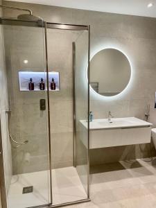 ein Bad mit einer Dusche, einem Waschbecken und einem Spiegel in der Unterkunft Pottery Gate, Bowness-on-Windermere in Bowness-on-Windermere