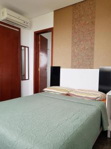 1 dormitorio con 1 cama grande y edredón verde en Solar Alcantara & Lazzarotto (Residencial), en Bombinhas