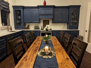 a kitchen with a wooden table and blue cabinets at The 1890 Freeman House in Galveston