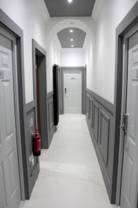 a hallway with white walls and white floors and doors at Laurieston Inn 