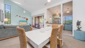 a dining room and living room with a table and chairs at Wailea Ekahi 21F in Wailea