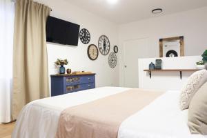 a bedroom with a white bed and a blue dresser at Lugar do Ourives Boutique Hotel in Senhora das Febres