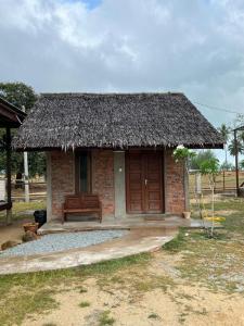 una pequeña cabaña con un banco delante en Rembulan Escape - The Red Bowl, en Kampung Penarik