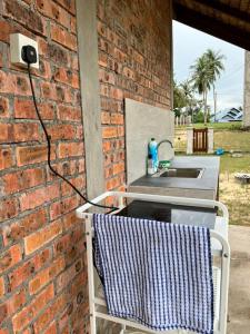 ein Handtuch auf einem Stuhl neben einer Ziegelmauer in der Unterkunft Rembulan Escape - The Red Bowl in Kampung Penarik