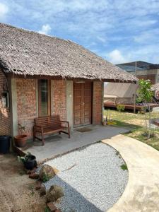 本那麗村的住宿－Rembulan Escape - The Red Bowl，砖房,有长凳和建筑