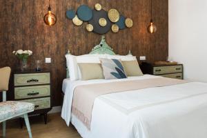 um quarto com uma cama branca e uma parede de madeira em Lugar do Ourives Boutique Hotel em Senhora das Febres