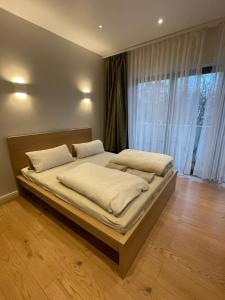 - un grand lit dans une chambre avec une grande fenêtre dans l'établissement Secret Studio Lux SPECIAL OFFER, à Berlin