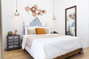 a bedroom with a bed and a mirror at Lugar do Ourives Boutique Hotel in Senhora das Febres