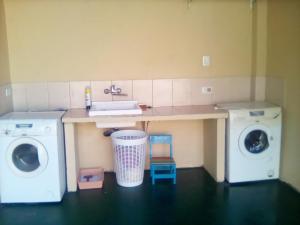 eine Waschküche mit einem Waschbecken und zwei Waschmaschinen in der Unterkunft Matices in Gualeguaychú
