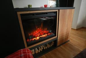 a fireplace with a fire inside of it at Apartman KUTAK Jahorina in Jahorina