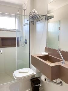 a bathroom with a sink and a toilet and a shower at Residencial Casa Flora - Centro de Bombinhas SC in Bombinhas