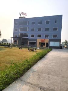 a large blue building with benches in front of it at Bellazio Suites Hotel & Resort in Bareilly