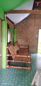 eine Holzbank in einem Zimmer mit Ziegelwand in der Unterkunft Lorenza's Cottage 1 in Buruanga