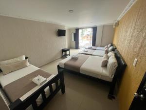 um quarto de hotel com duas camas e uma janela em Hotel Chico Real em Bucaramanga