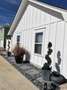 a white building with potted plants in front of it at Hermosa Flor apartment( Duplex). in Pensacola