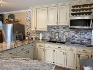 a kitchen with white cabinets and a sink at Hermosa Flor apartment( Duplex). in Pensacola