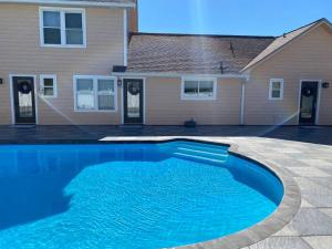 a blue swimming pool in front of a house at Hermosa Flor apartment( Duplex). in Pensacola